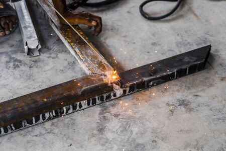 The mechanic was using a tool to weld iron until it sparked