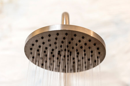 shower head in bathroom with water drops flowingの写真素材