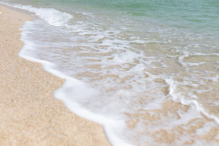Soft wave of the sea on the sandy beach. Selective focus.の写真素材
