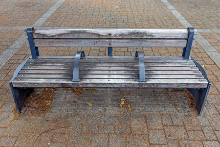 Wooden bench in the city park. Bench on the sidewalk.の写真素材