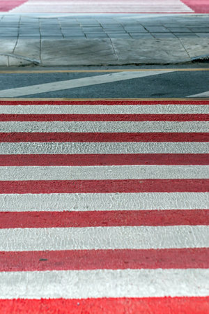 Red and white zebra crossing on the street in the city.の写真素材