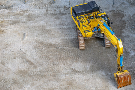 High angle view of excavator machine working on construction site with concrete background