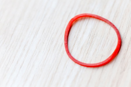 Red rubber ring on a wooden background. Shallow depth of field.の写真素材