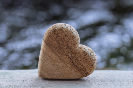 Heart shaped stone on a background of blurred nature. Selective focus.の写真素材