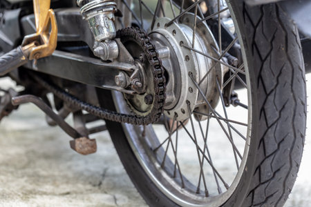Close up of the front wheel of a motorcycle with chain and gear