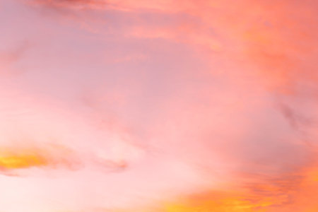 Sunset sky background with tiny clouds in pink and orange colors.