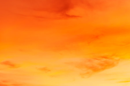 Sunset sky background with tiny clouds. Natural background of orange sunset sky.の写真素材
