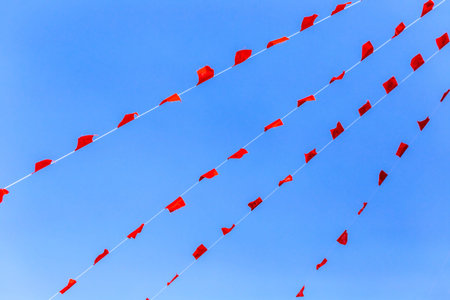 Red and white flags on blue sky background. Celebration and festival concept.