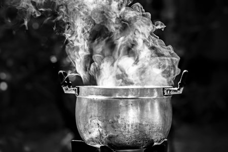 Cooking in a pot on a fire. Black and white.