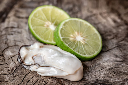 Fresh oysters and lime on wooden background. Seafood concept.の写真素材