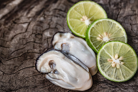 Fresh oysters and lime on wooden background. Healthy food concept.の写真素材