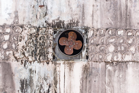 Old rusty fan on concrete wall in the old town, Thailand.