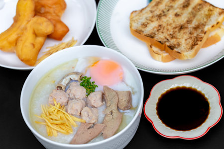 rice porridge with pork, rice gruel and fried egg in white bowl