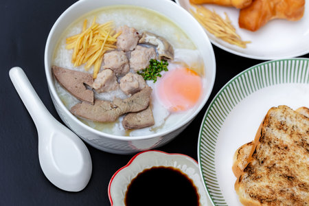 Pork rice porridge or congee with fried egg, pork and bread