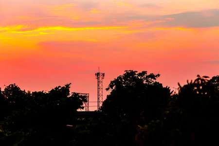 Silhouette of telecommunication tower on the sunset sky background.