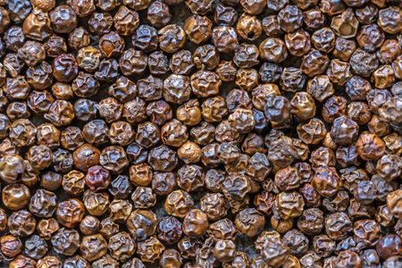 Pepper seeds background. Close up of black peppercorns.