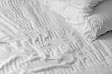 White clean bedding sheets and pillows in the morning sunlight.の写真素材