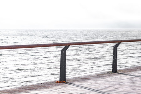 Seascape with a wooden pier and a railing in the foregroundの写真素材