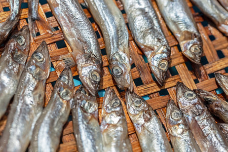 Dried salted fish on a bamboo tray in the market.