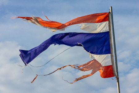 old tattered thailand flag in the strong windの写真素材