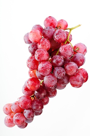 A bunch of red grapes on a white background.の写真素材