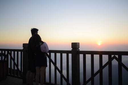 The couple hugging together looking in the sunsetのeditorial素材