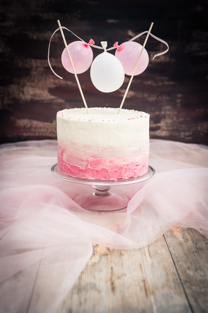 beautiful birthday wedding cake with cream cheese frosting. Decorated with tiny balloons. Selective focus.の写真素材