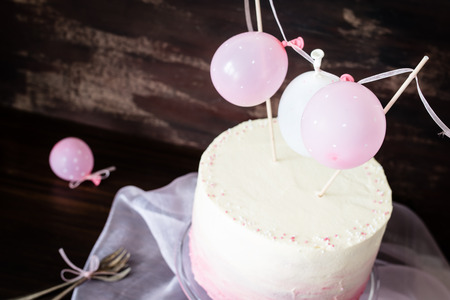 beautiful birthday wedding cake with cream cheese frosting. Decorated with tiny balloons. Selective focus.の写真素材