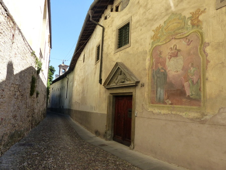 Religious painting on a wall of a building in an ancient narrow street in the historic center of Bergamo Alto. Italyのeditorial素材