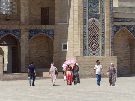 People walking under the sun inside a madrasa in Tashkent in Uzbekistan.のeditorial素材