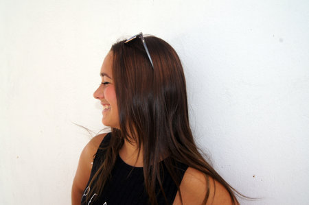 Portrait of a beautiful young woman on a white wall background.の写真素材