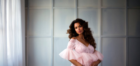 Beautiful african american woman in pink dress, indoor photoの素材