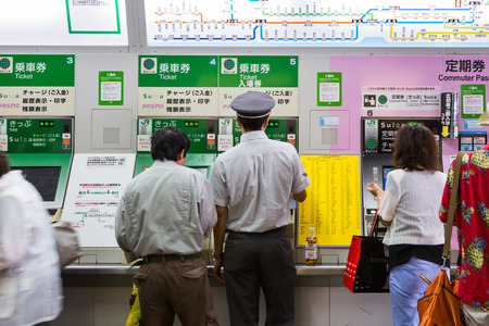 TOKYO, JAPAN-CIRCA JULY, 2014:Train station staff helps the elderly buy train ticket.