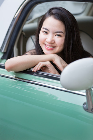 Asian lady smiling in a vintage carの写真素材