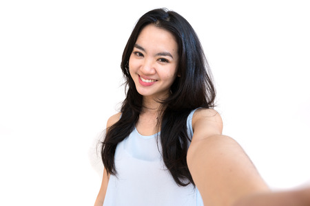 An asian woman taking self portrait isolated on whiteのeditorial素材