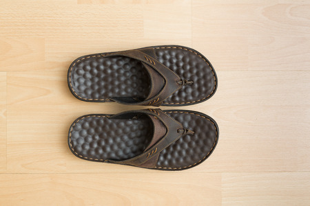 A pair of flip flops on wooden surface backgroundの写真素材