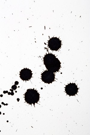 Black ink drop splatter on white art paperの写真素材