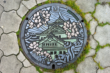 OSAKA, JAPAN - CIRCA APRIL, 2016: Manhole cover in Osaka, Japan. The Osaka castle engraved on to a manhole cover as a symbol of an important city's landmark.のeditorial素材