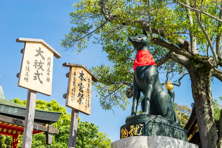 Fushimi inari stone fox guarding wooden gatesのeditorial素材