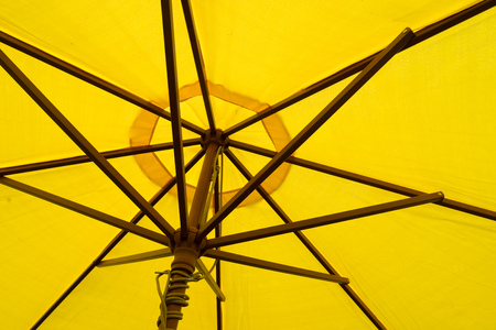 Close up on the underside of a yellow umbrellaの写真素材