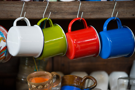 Colorful galvanized iron mug hanging in a cafeの写真素材