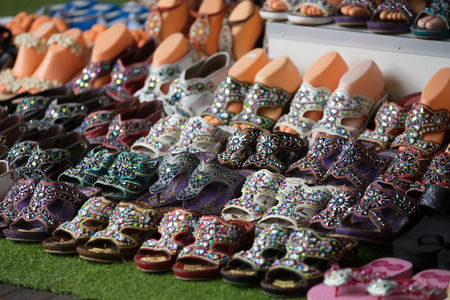 Colorful handmade shoes for sale in a marketの写真素材