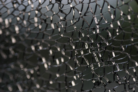 Damaged glass window fracture texture, close up