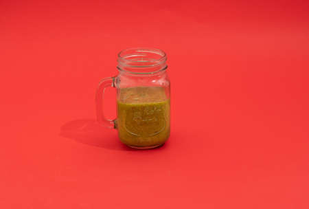 green healthy juice on a red backgroundの写真素材