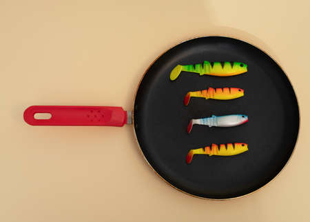 fishies baits in the pan  on a yellow backgroundの写真素材
