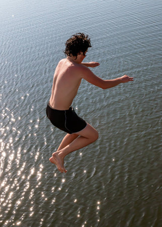 Georgia, a young boy jumping into the seaの写真素材