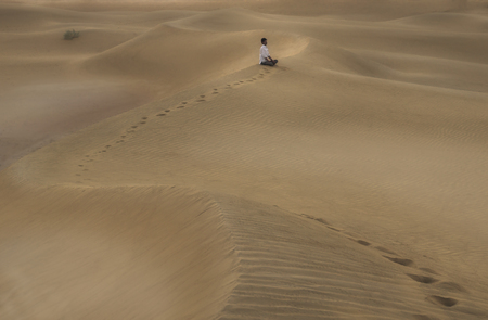 early morning meditation in the desert of Jaisalmer, Indiaの写真素材