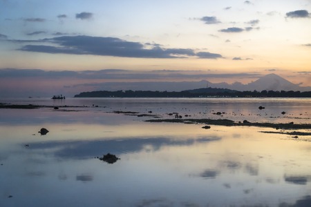 Boat in the ocean with view to Gili Meno from Gili Air during sunset, Lombok, Indonesiaの写真素材