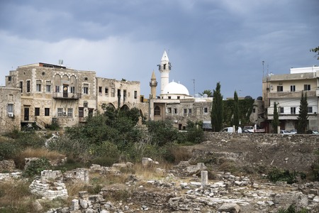 Old city with mosque and ruins with dark dramatic cloudscape in Tyre, Sour, Lebanonの写真素材