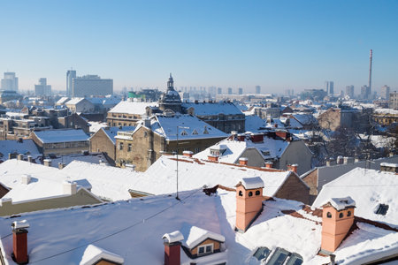 Panorama view over Zagreb with dome and chimneys during winter with snow over the roofs during sunny weather, Zagreb, Croatia, Europeのeditorial素材
